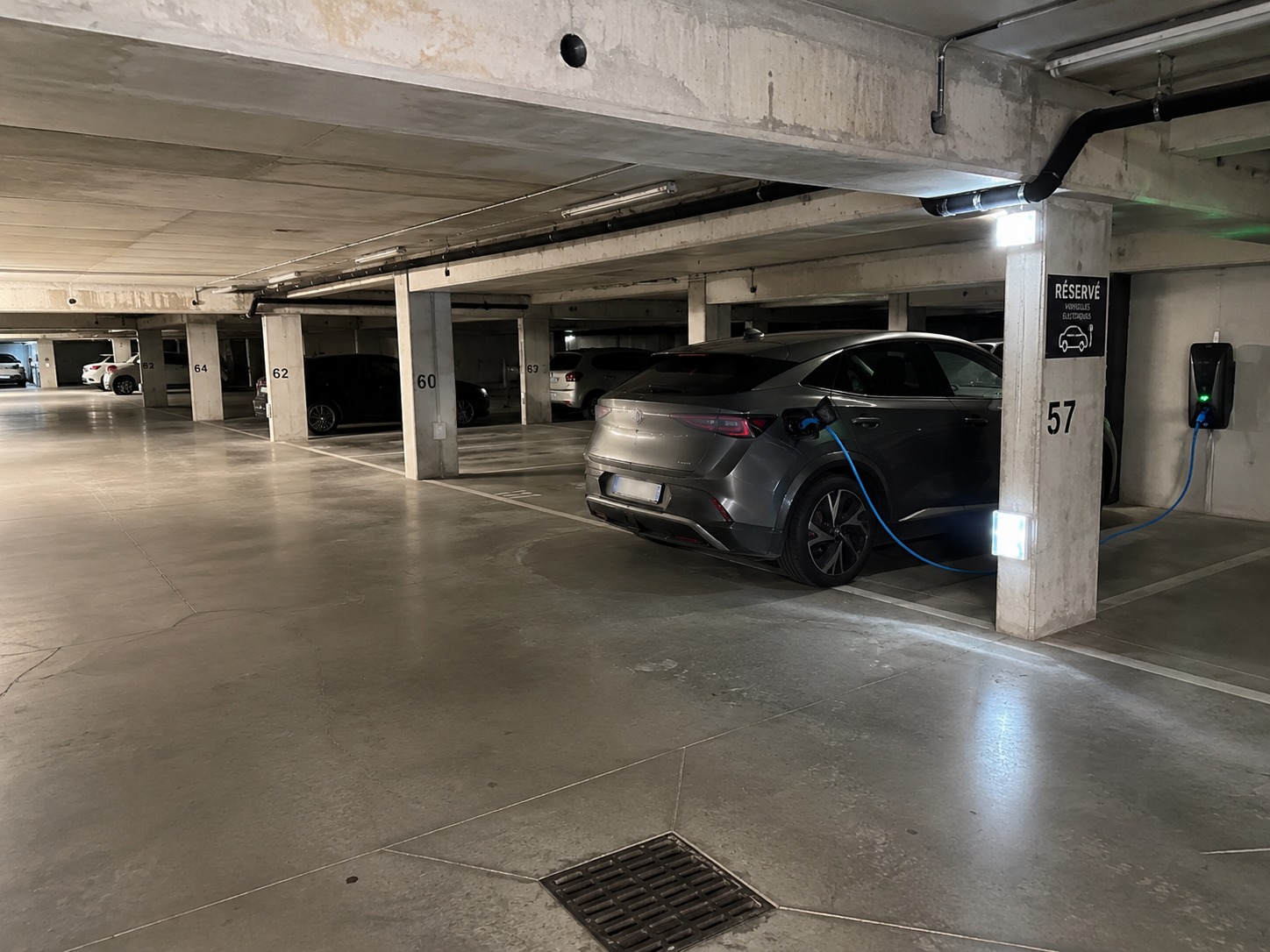Emplacement réservé véhicule électrique avec borne de recharge en parking couvert CDG